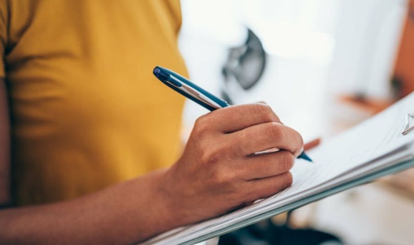 Persona firmando uno de los servicios de Cuatro Asociadas (seguro de familia)
